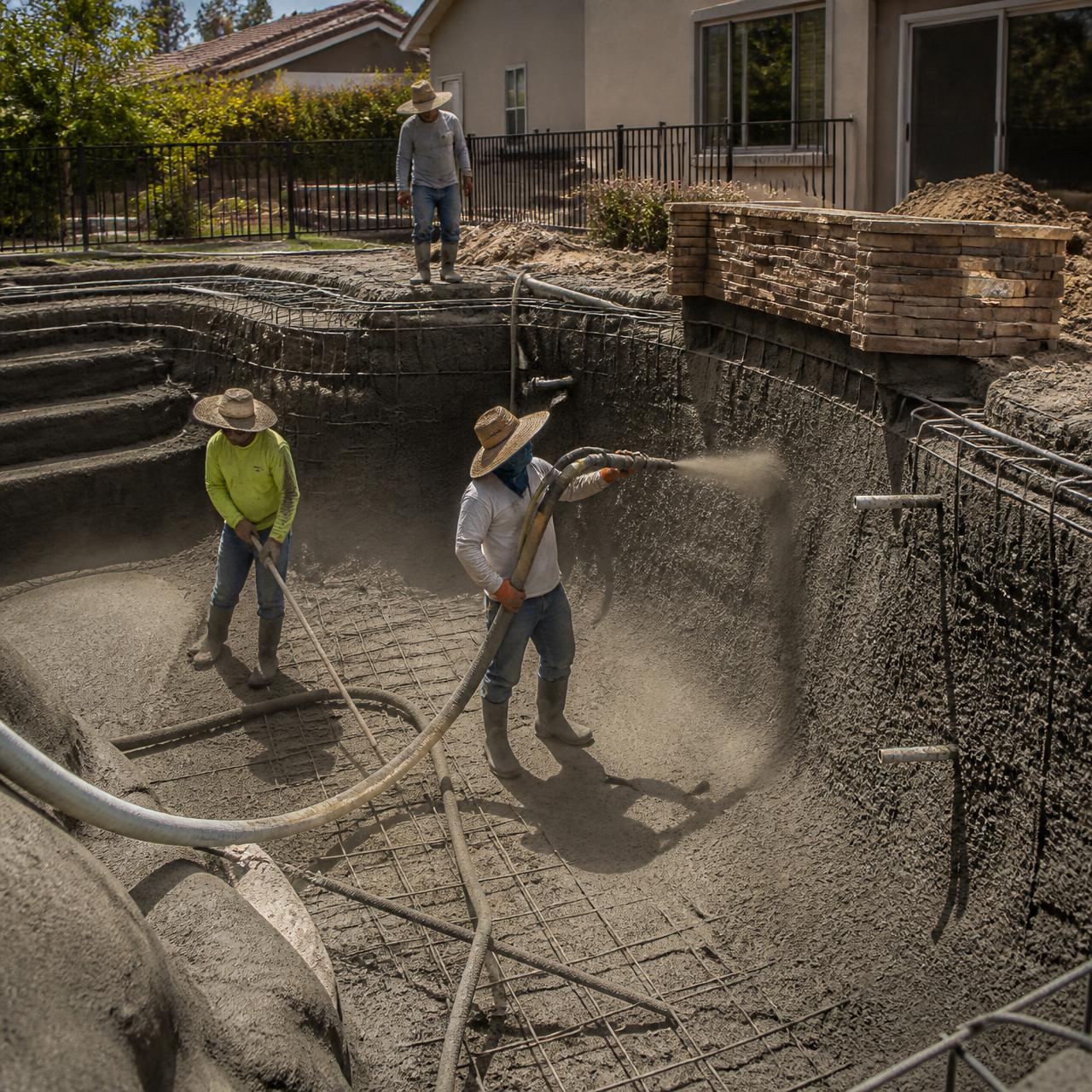 Pool building crew shooting gunite on a new residential pool